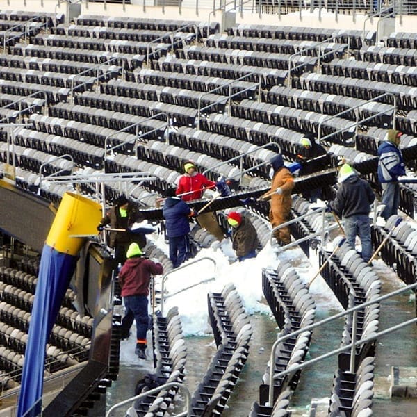 Workers using a Superchute stadium snow chute. Workers using a Superchute stadium snow chute.